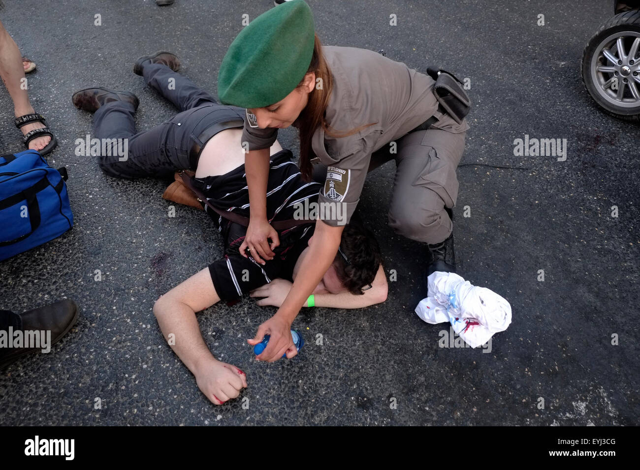 An Israeli border police woman holds an injured man after being stabbed by an ultra Orthodox Jewish man at the annual Gay Pride Parade in Jerusalem on 30 July 2015. Israel is widely seen as having liberal gay rights policies, despite the hostility shown towards homosexuals, particularly men, from the ultra-Orthodox Jewish community Credit:  Eddie Gerald/Alamy Live News Stock Photo