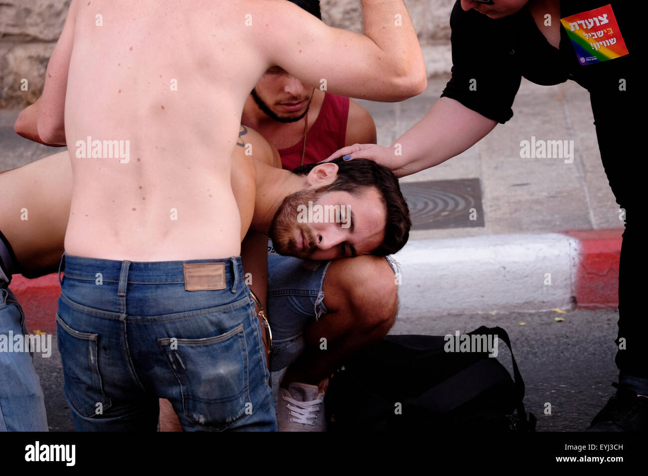 Young Israelis holding an injured man after being stabbed by an ultra Orthodox Jewish man at the annual Gay Pride Parade in Jerusalem on 30 July 2015. Israel is widely seen as having liberal gay rights policies, despite the hostility shown towards homosexuals, particularly men, from the ultra-Orthodox Jewish community Credit:  Eddie Gerald/Alamy Live News Stock Photo