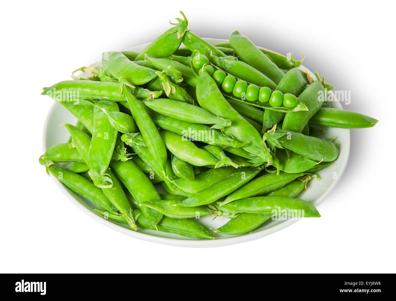 Big pile opening and closing pea pods on white plate isolated on white background Stock Photo