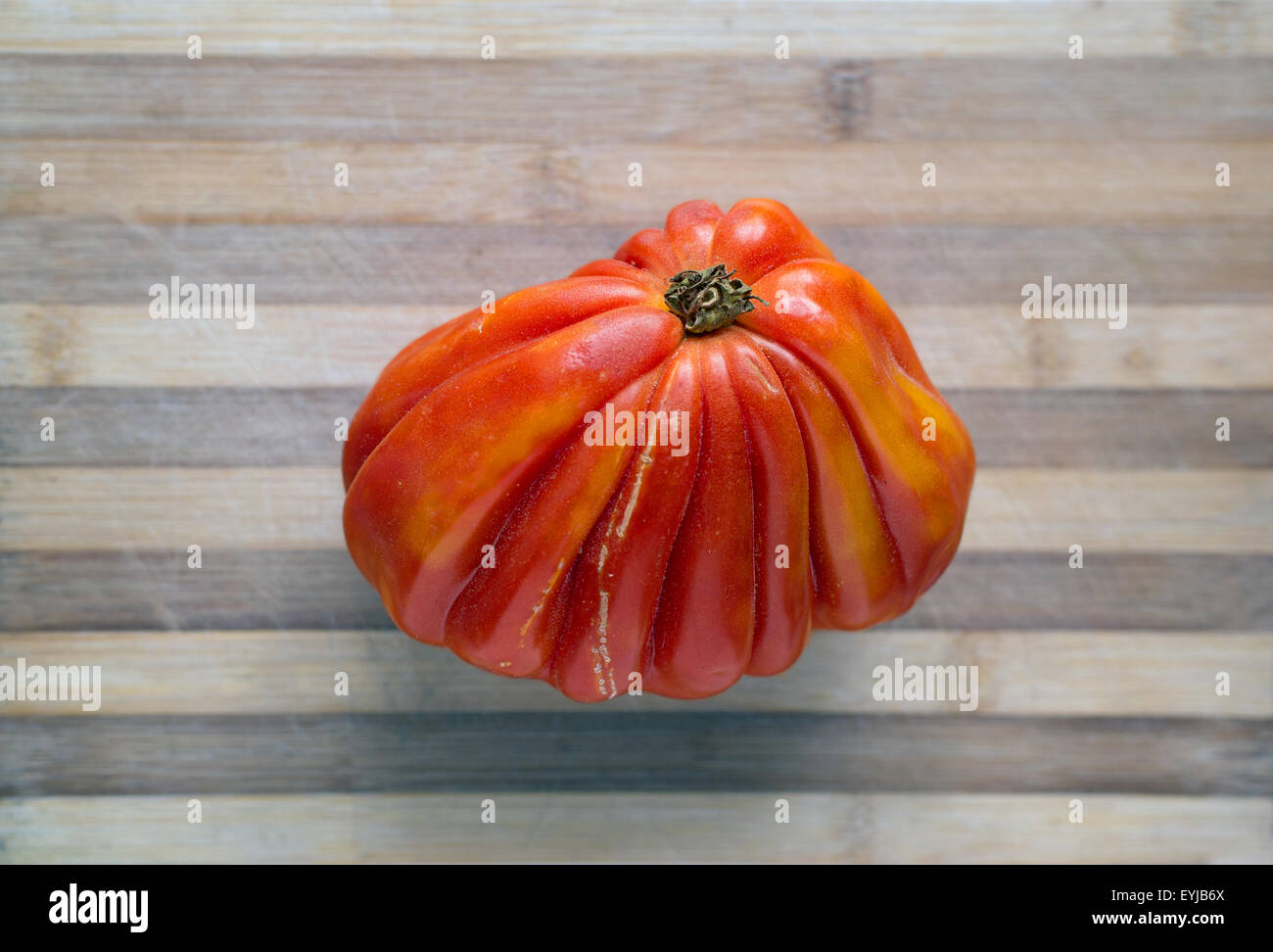 Fresh ecologic beefsteak tomato in a rustic table. Stock Photo
