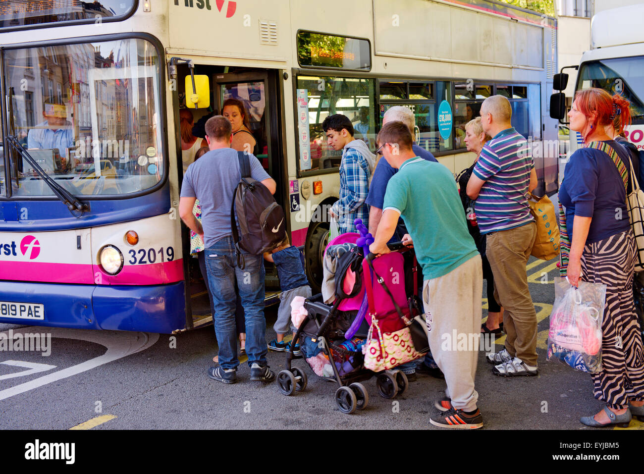 Passengers queuing at bus stop to board local double decker bus, Bristol, UK Stock Photo