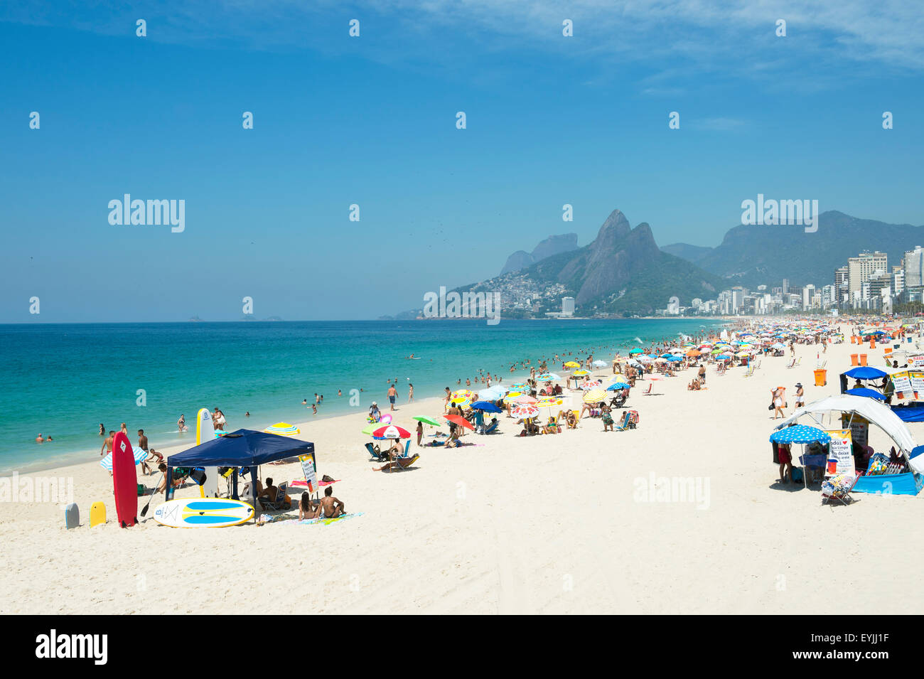 RIO DE JANEIRO, BRAZIL - FEBRUARY 08, 2015: Beachgoers relax near tent with stand up paddle surfboards on Ipanema Beach. Stock Photo