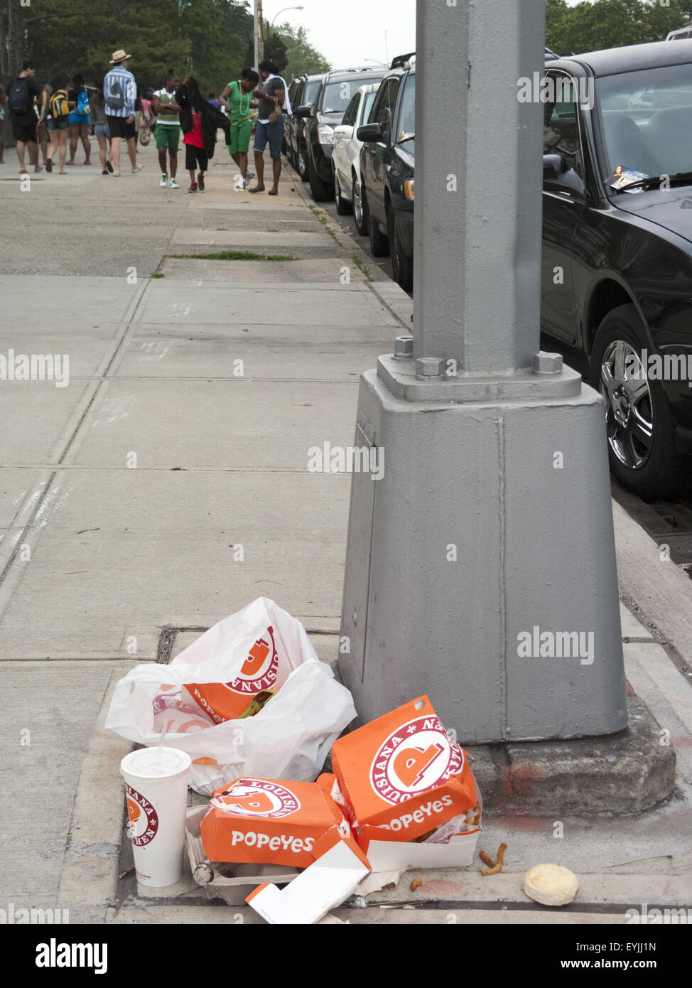 Boxes and cups left over from fast food meal litter sidewalk in Coney