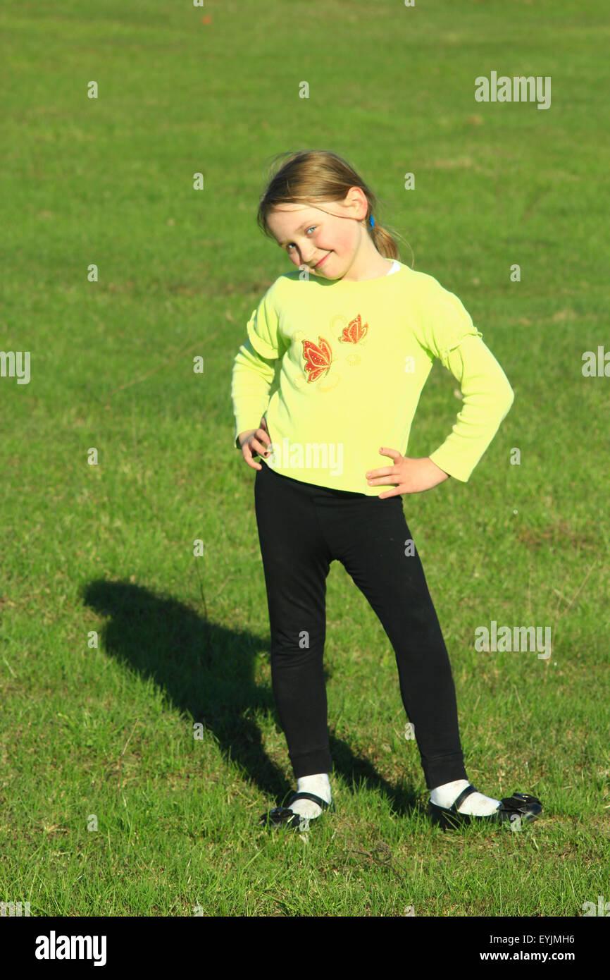 little girl standing at in the majestic position on the green grass Stock Photo