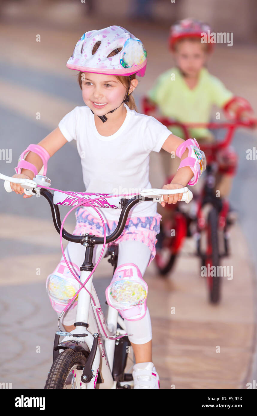 Happy children racing on bicycles, brother and sister organized sports