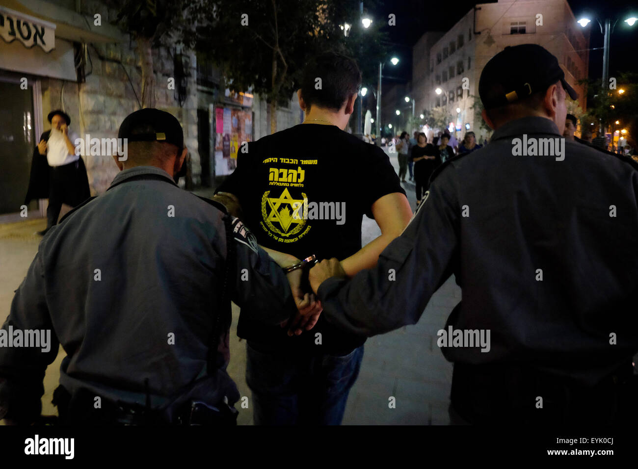 Jerusalem Israel 30th July 2015. An activist of Lehava group is detained by Israeli policemen in downtown Jerusalem on 30 July 2015. Lehava is an Israeli organization whose primary objective is opposing assimilation of Jews, objecting to any personal or business relationships between Jews and non-Jews. It has an anti-miscegenation focus, denouncing marriages between Jewish women and non-Jewish. Lehava also accuses homosexuals of harming Jewish nation. Credit:  Eddie Gerald/Alamy Live News Stock Photo