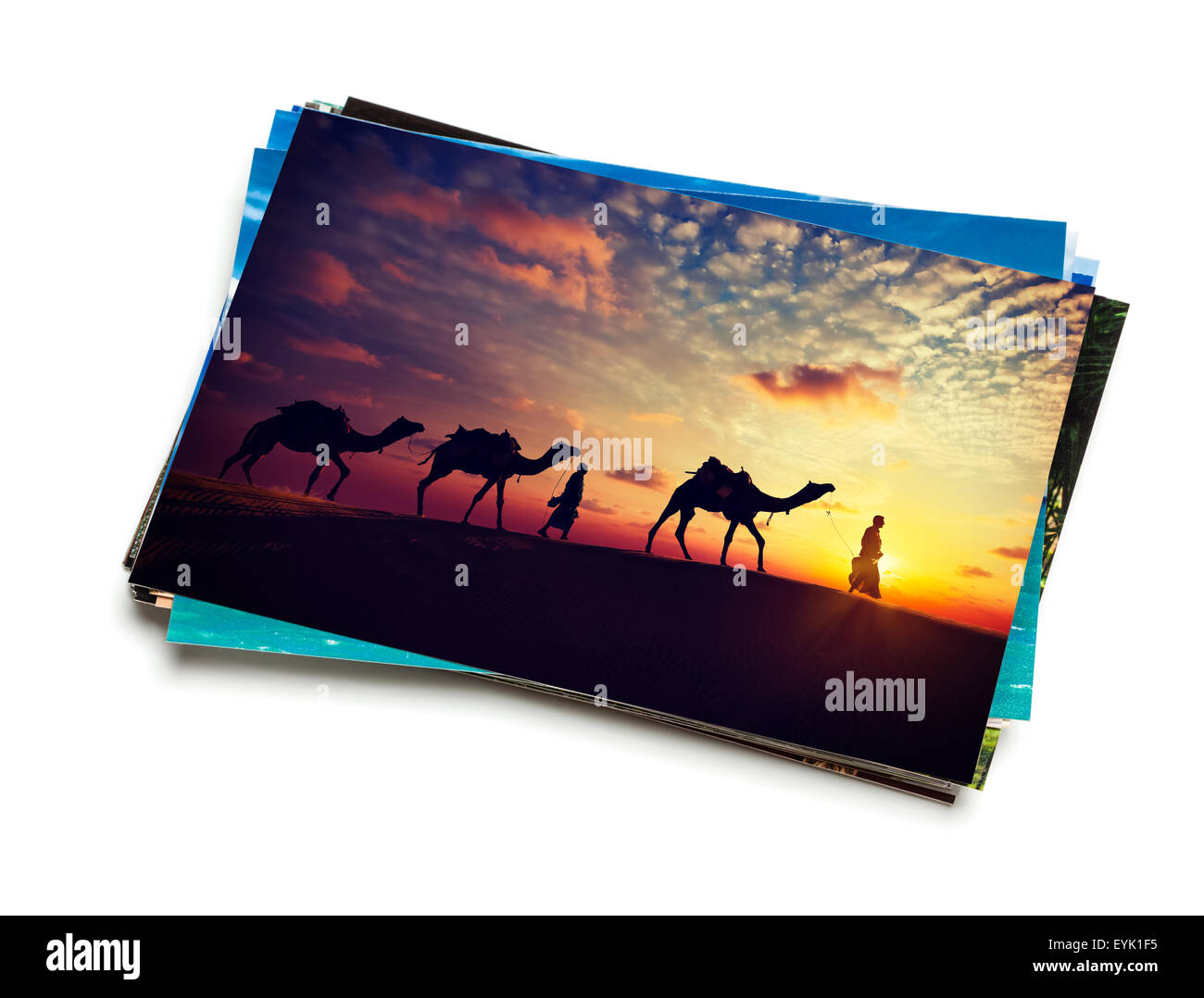 Holidays travel concept creative background - stack of vacation photos with camel caravan sunset image on top isolated on white Stock Photo