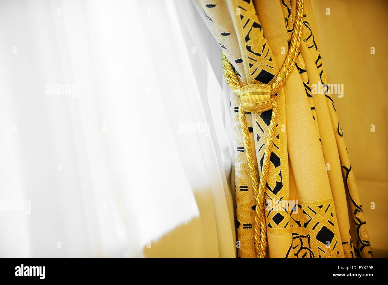 Luxury yellow window curtain with decorative tassel Stock Photo