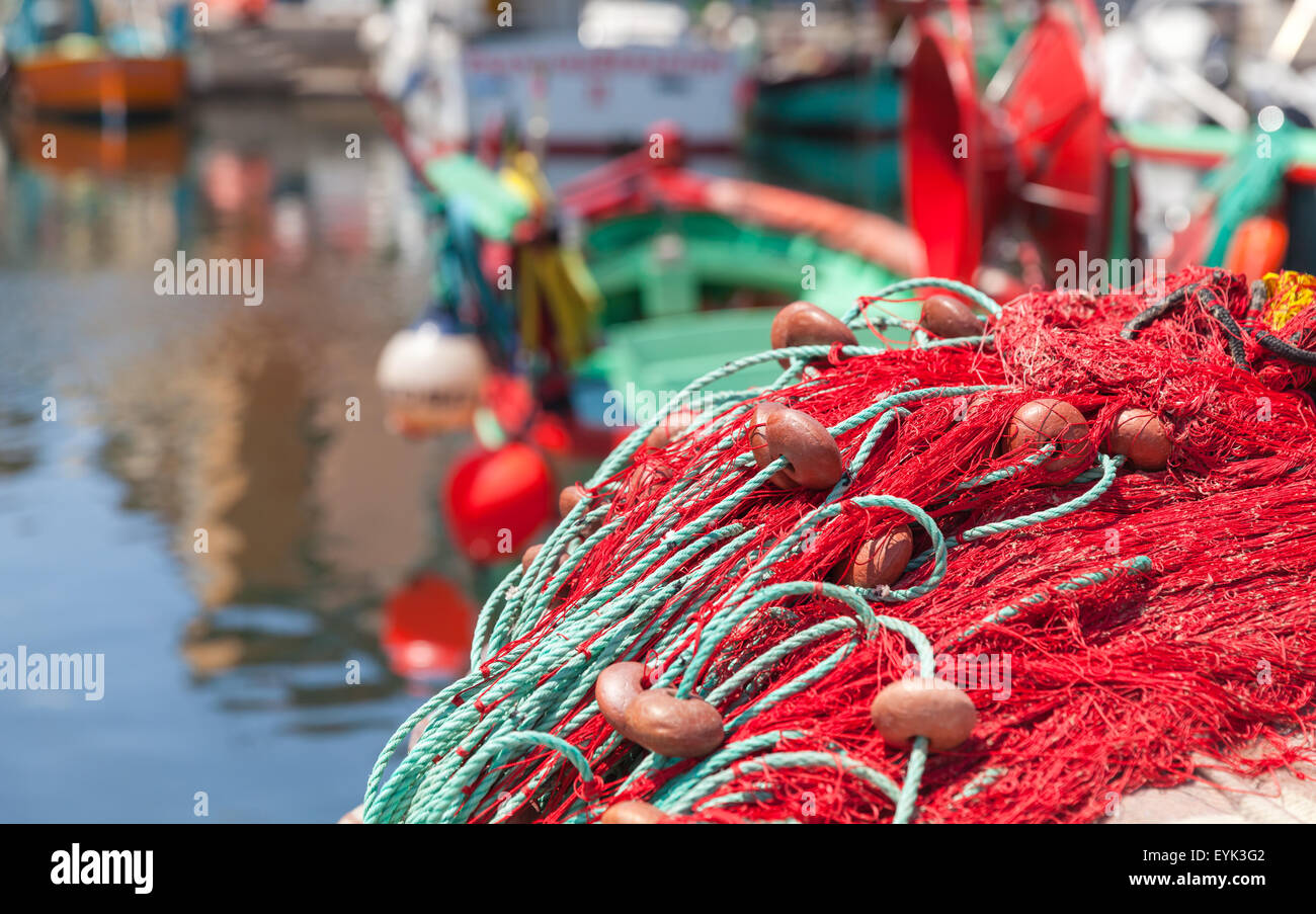 Colorful fishing net laying on a pier, closeup photo with selective focus  and blurred port background Stock Photo - Alamy