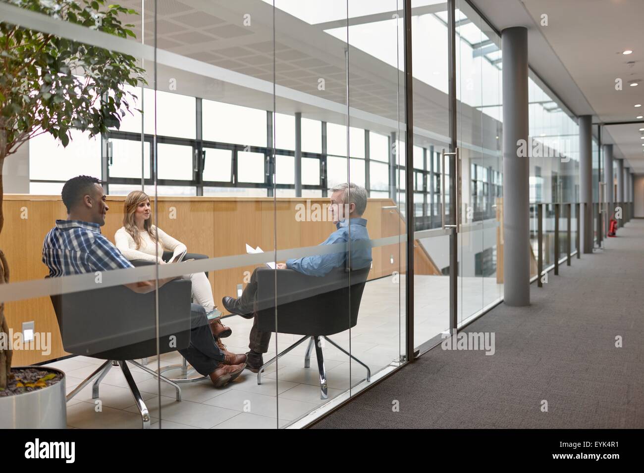 Businessmen and woman talking at conference room meeting Stock Photo
