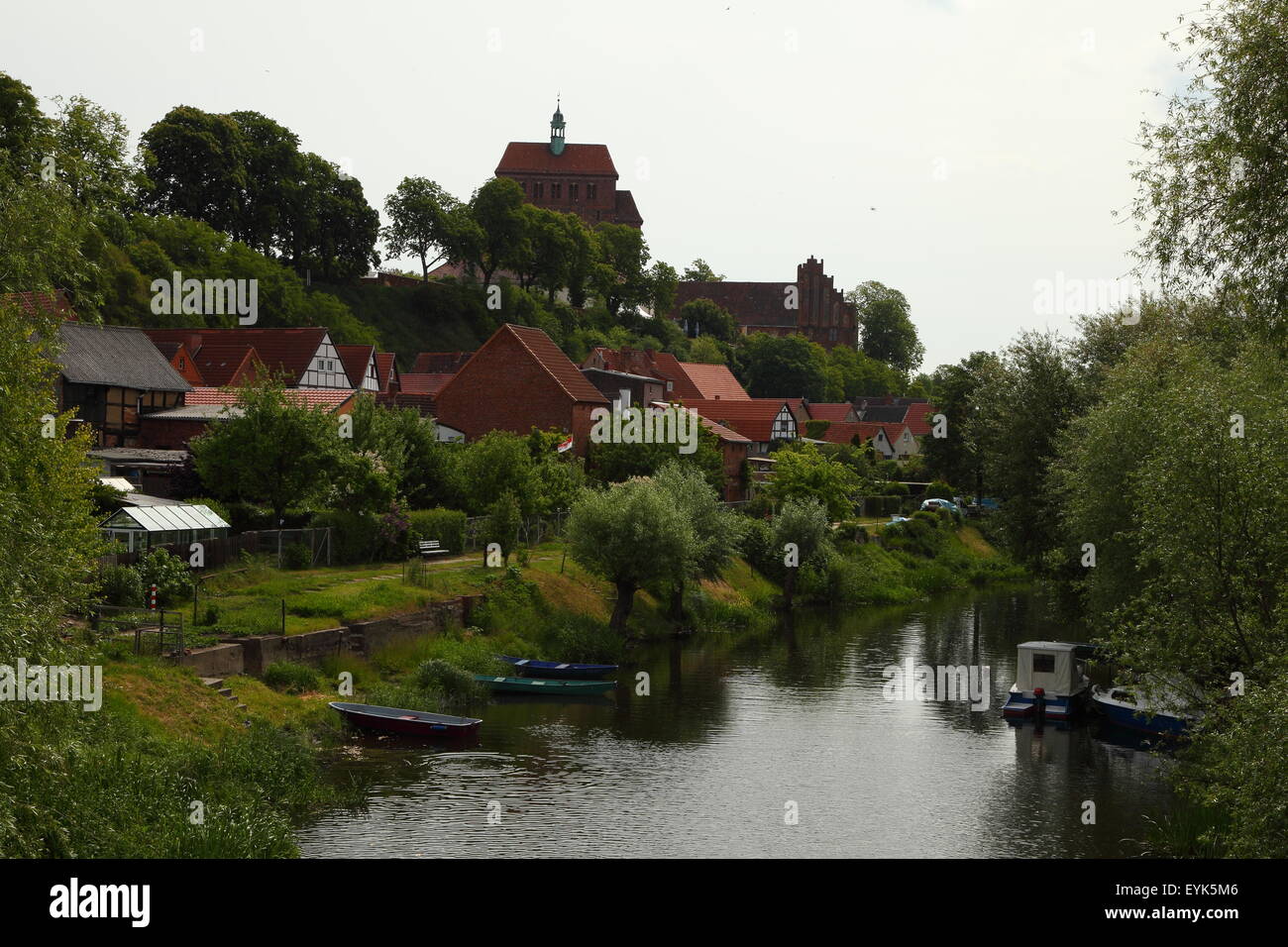Cathedral on a hill and houses near a river Stock Photo