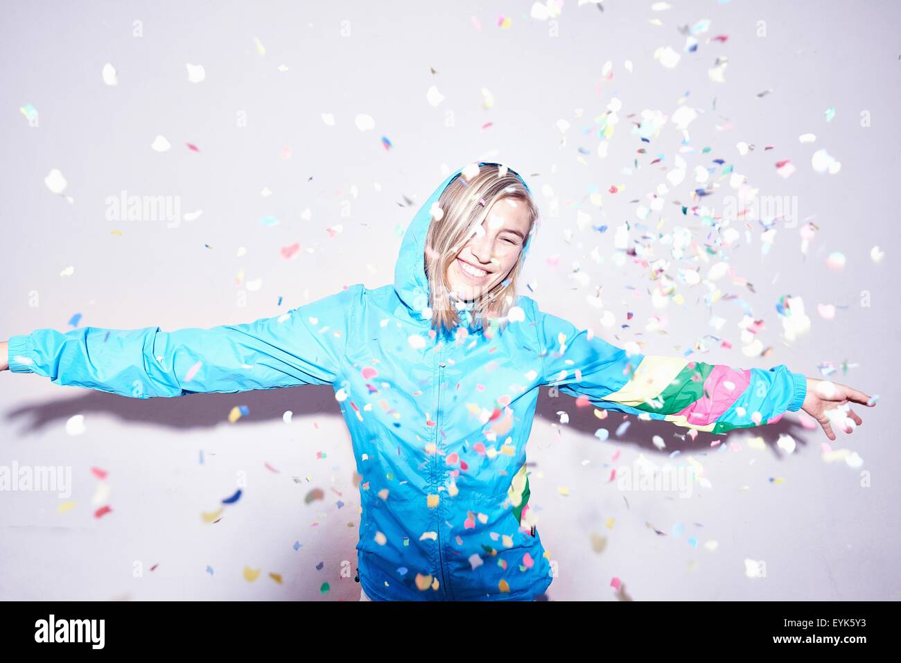 Studio portrait of young woman throwing confetti Stock Photo