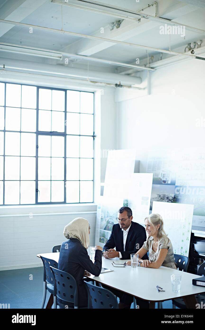 Two businesswomen and man talking at office meeting Stock Photo - Alamy
