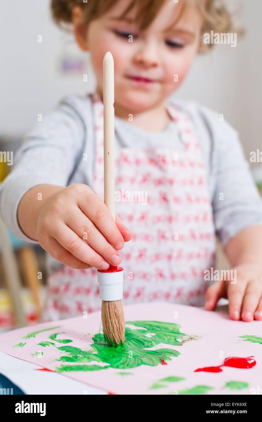 Girl painting on paper at home Stock Photo - Alamy