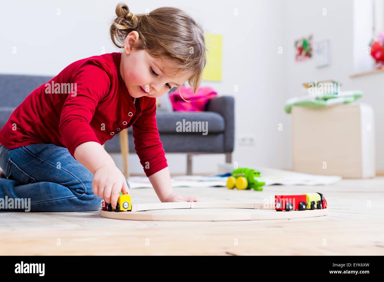 Girl playing with toy cars at home Stock Photo