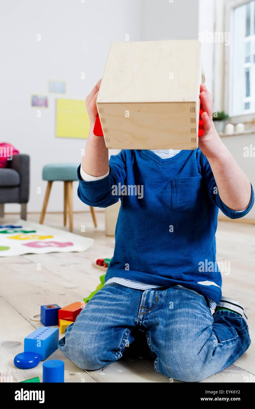 Boy covering face with wooden box Stock Photo