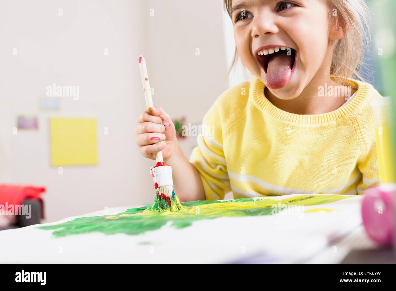 Girl painting and sticking out tongue Stock Photo