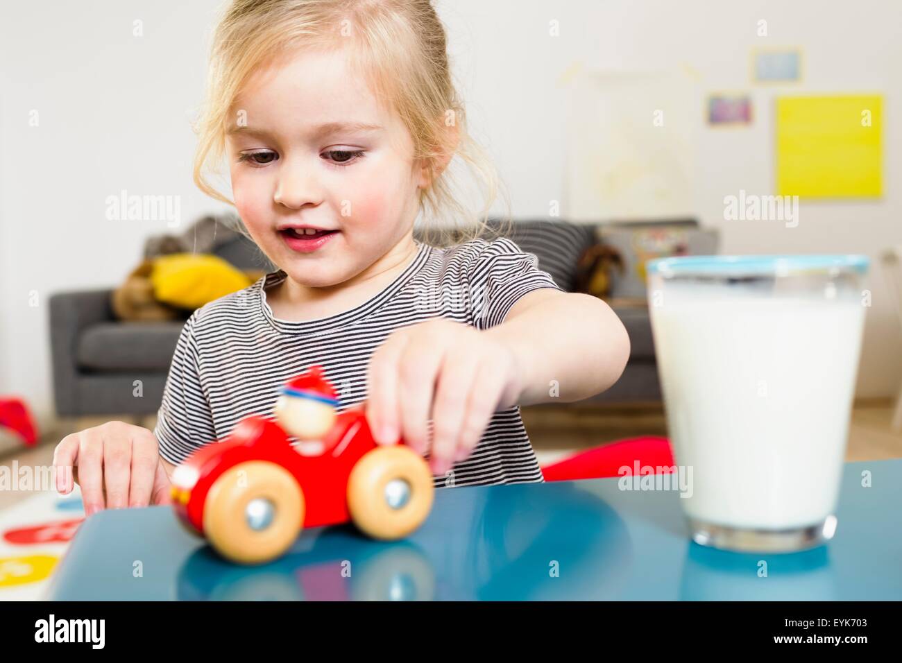 Girl playing with toy car at home Stock Photo - Alamy