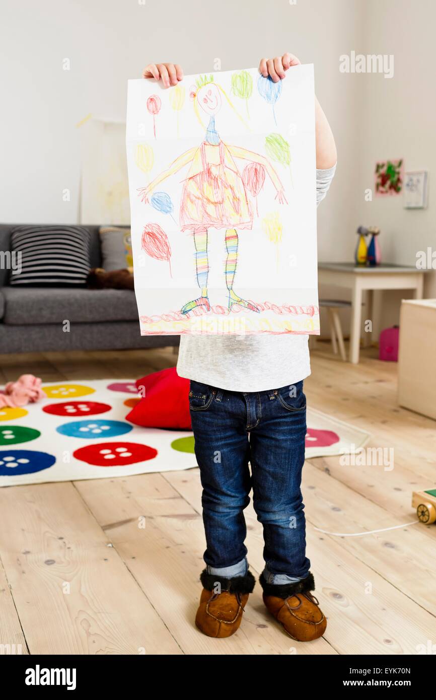Toddler holding up painting at home Stock Photo