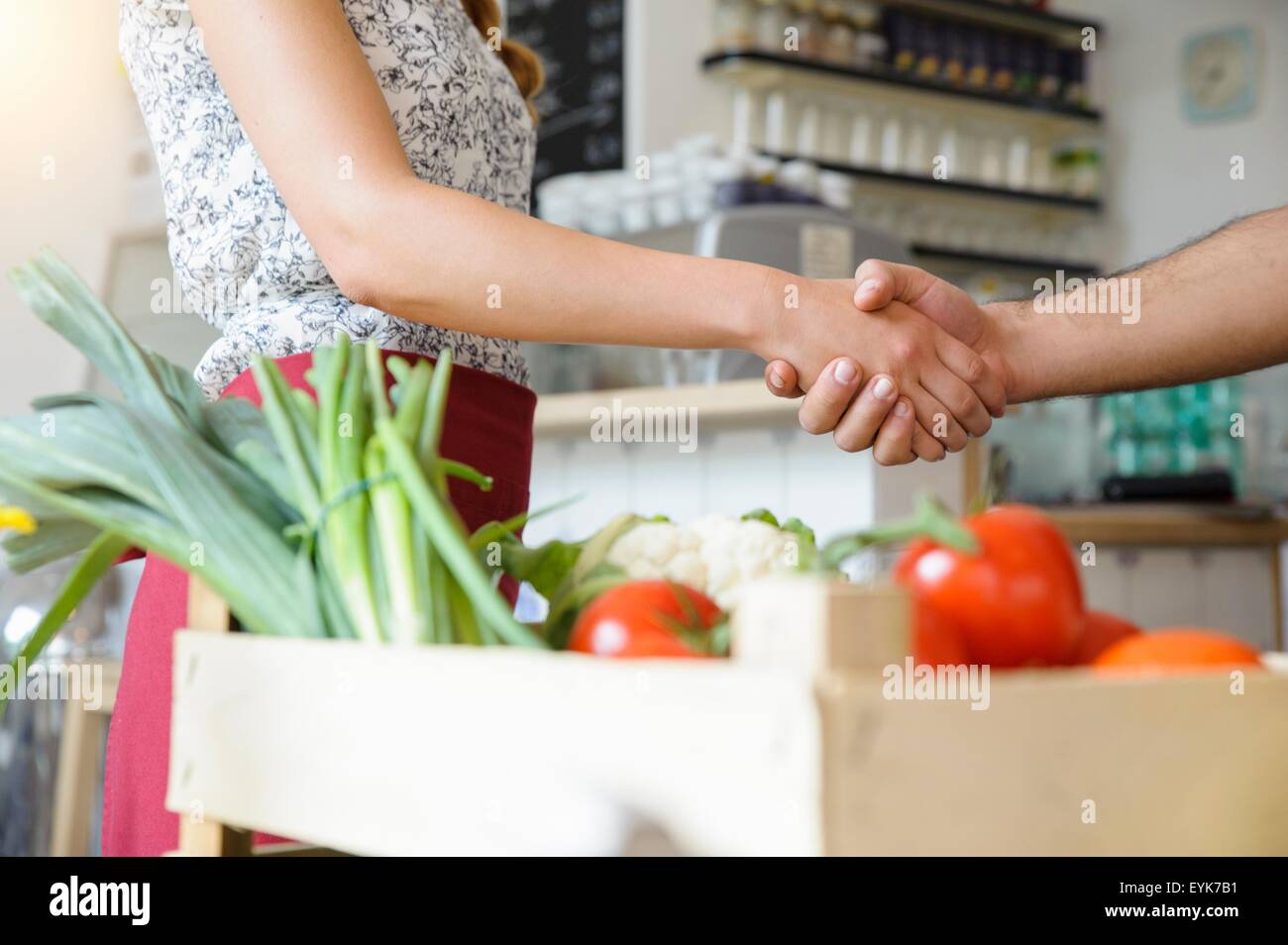 Man delivering crate of vegetables to shopkeeper Stock Photo