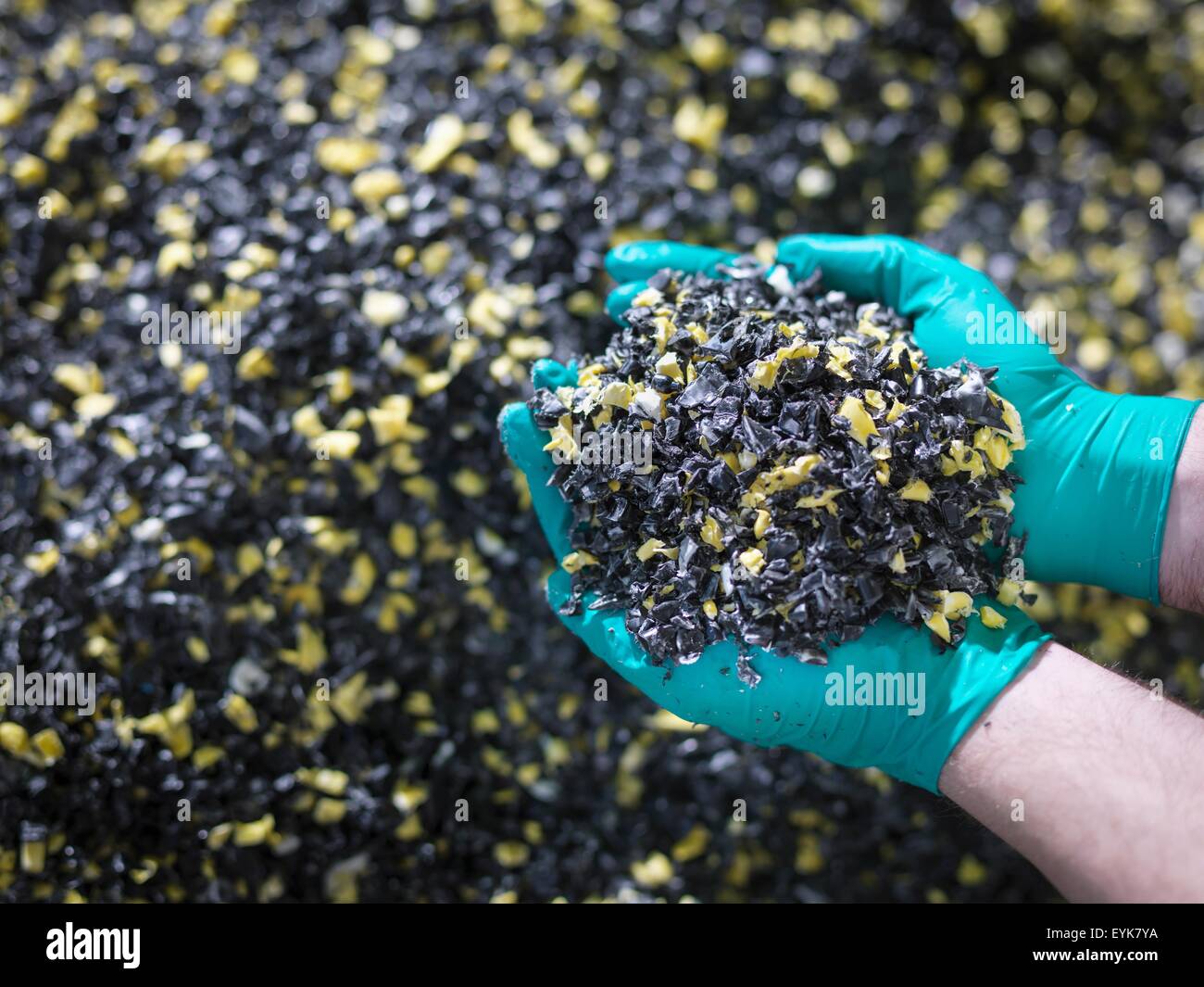 Worker holding recycled plastic in plastics factory, close up Stock