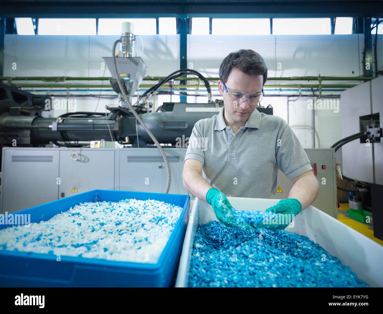 Worker inspecting recycled plastic in plastics factory Stock Photo Alamy