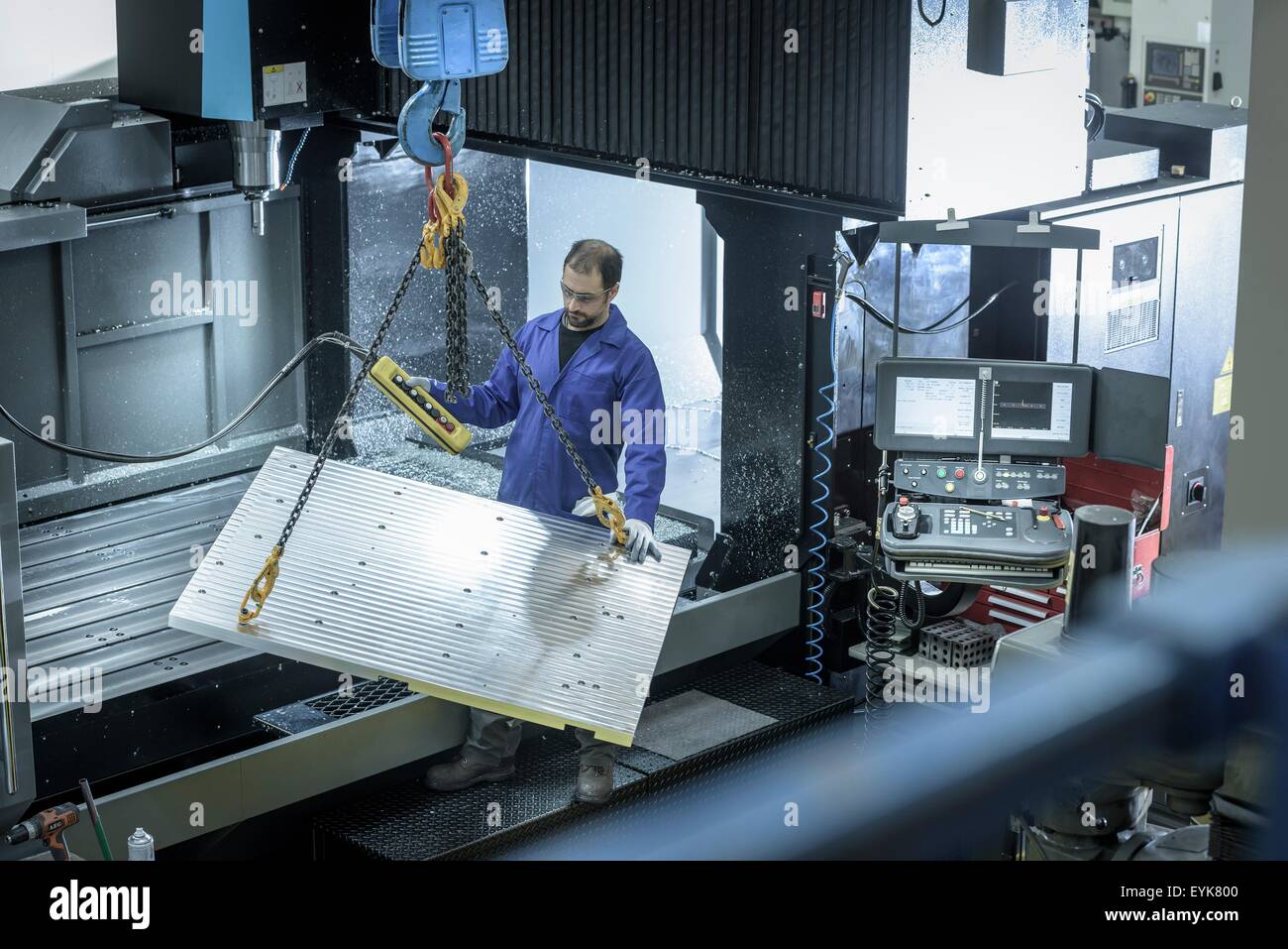 Overview of worker with large CNC machine in plastics factory Stock Photo
