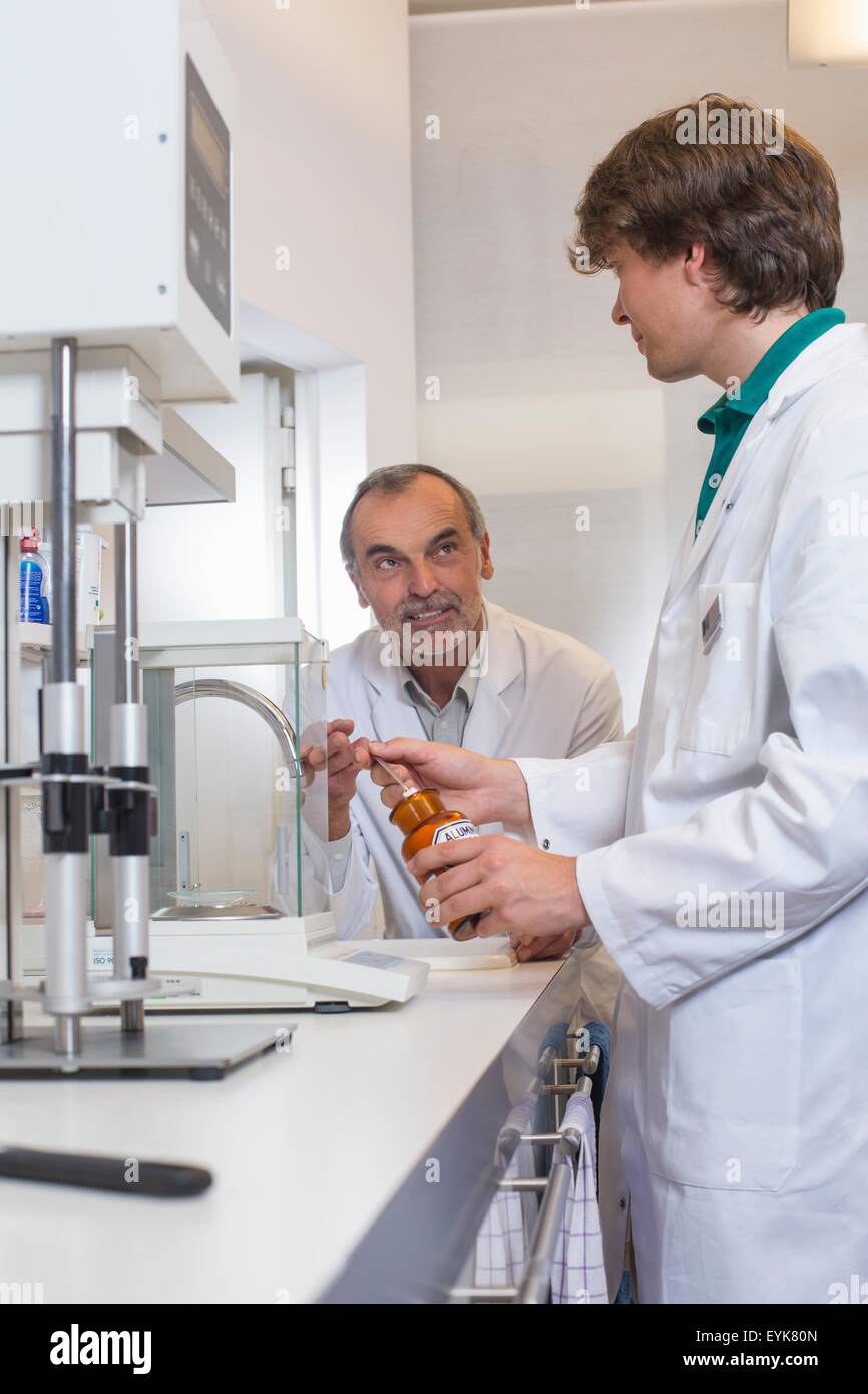 Pharmacist and trainee mixing medicine in pharmacy Stock Photo