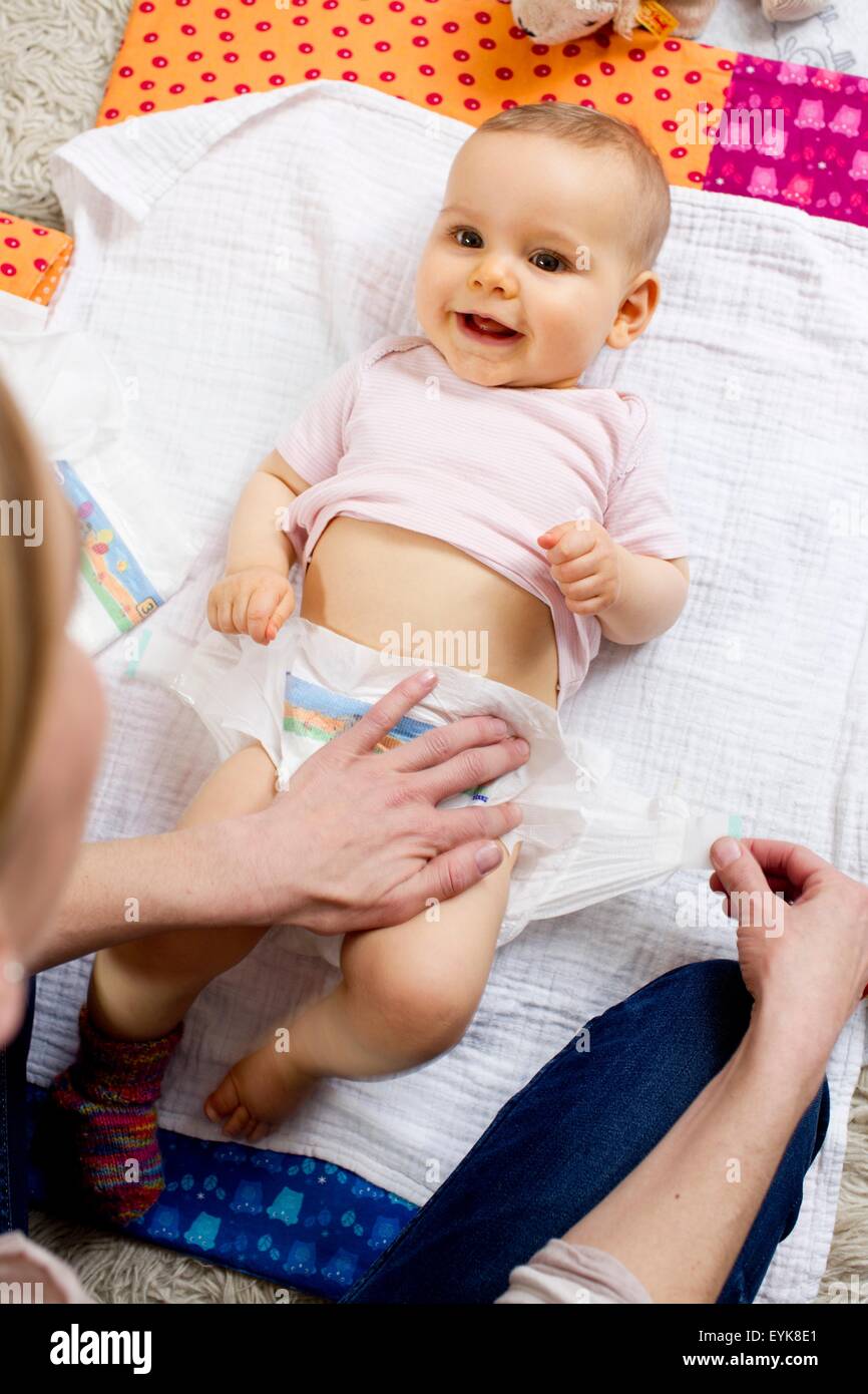 Mother changing nappy of baby girl Stock Photo