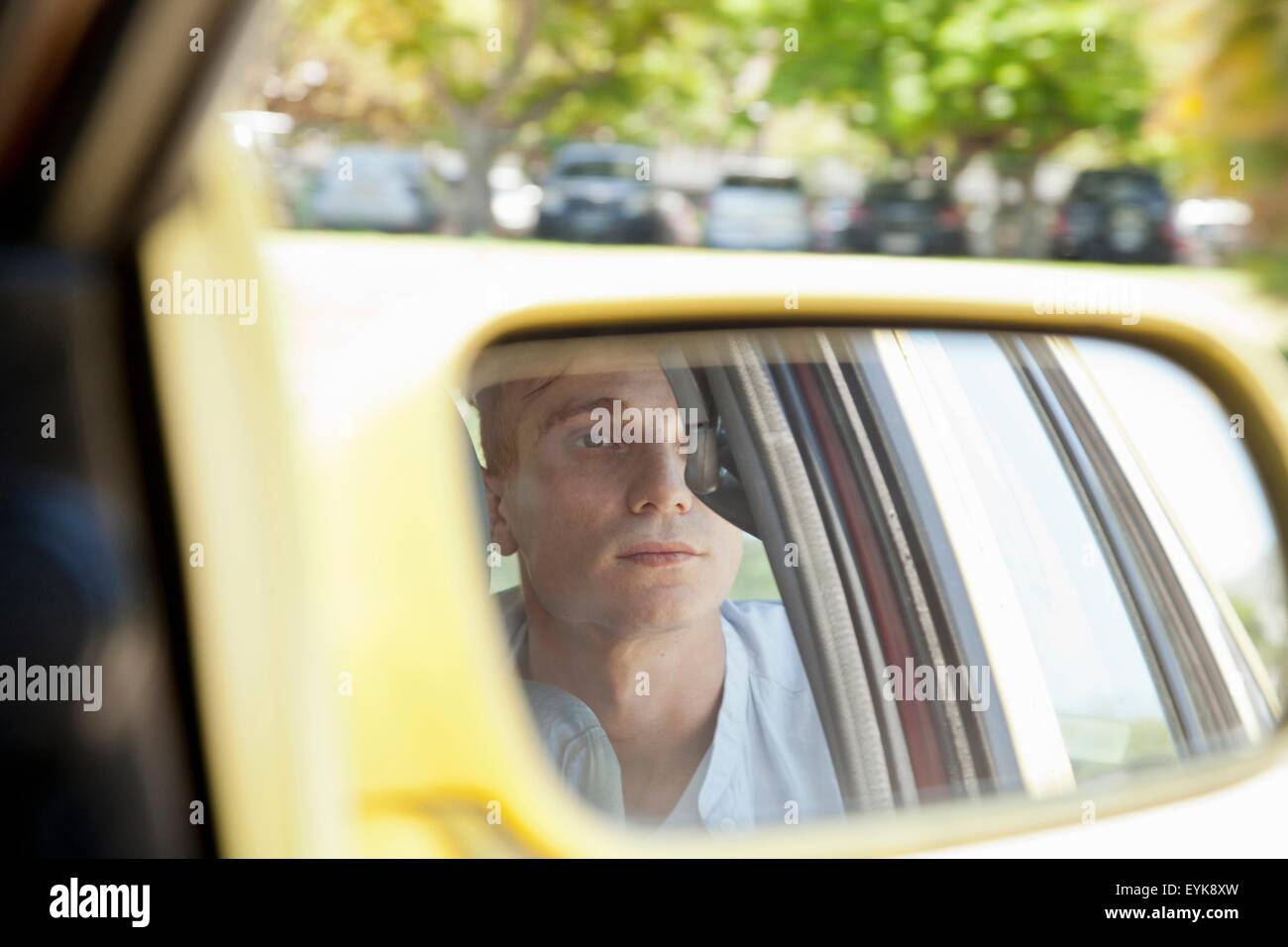 Reflection of young man in rear view mirror Stock Photo - Alamy