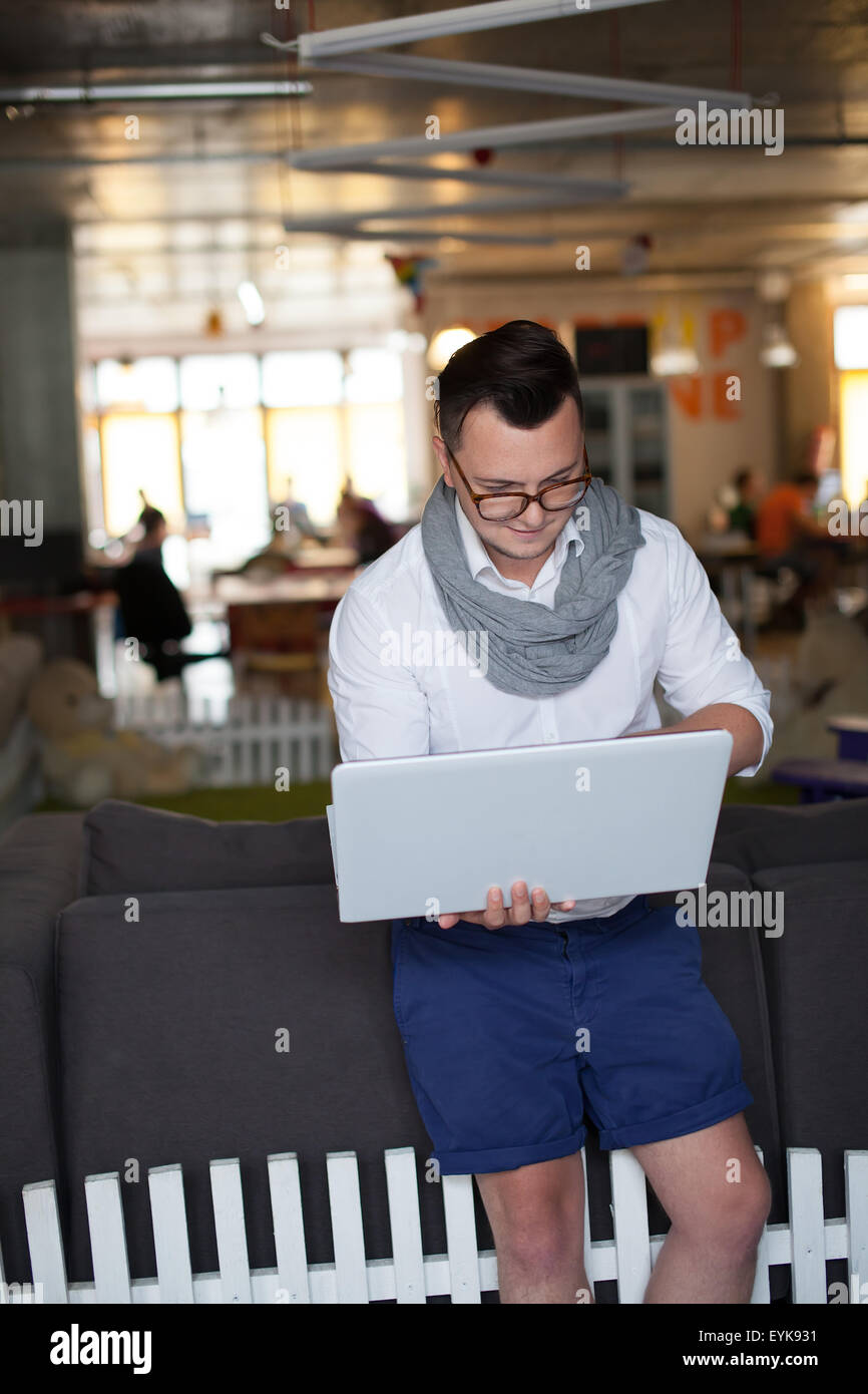 Stylish man using laptop in startup office Stock Photo