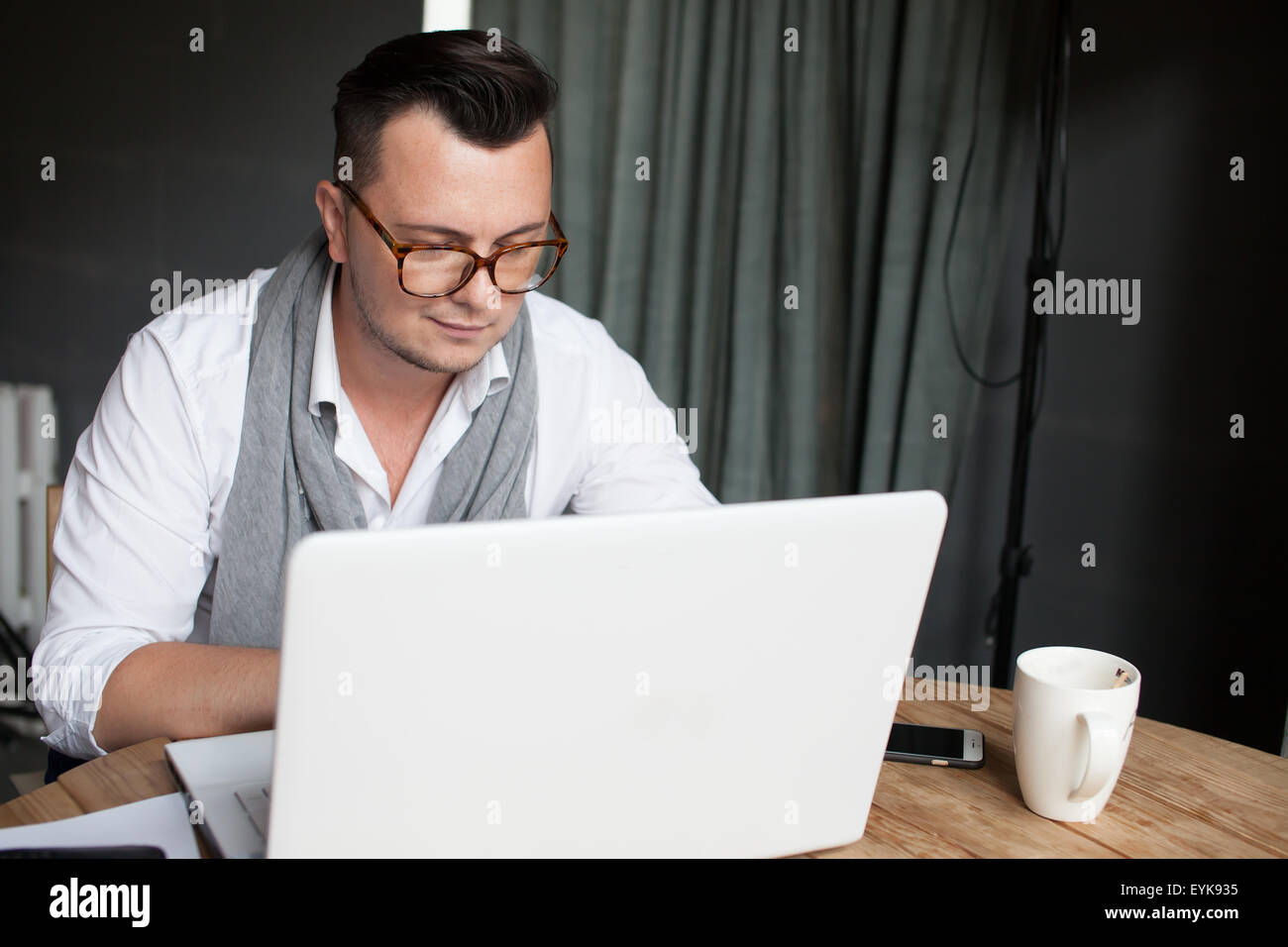 Stylish man using laptop in startup office Stock Photo