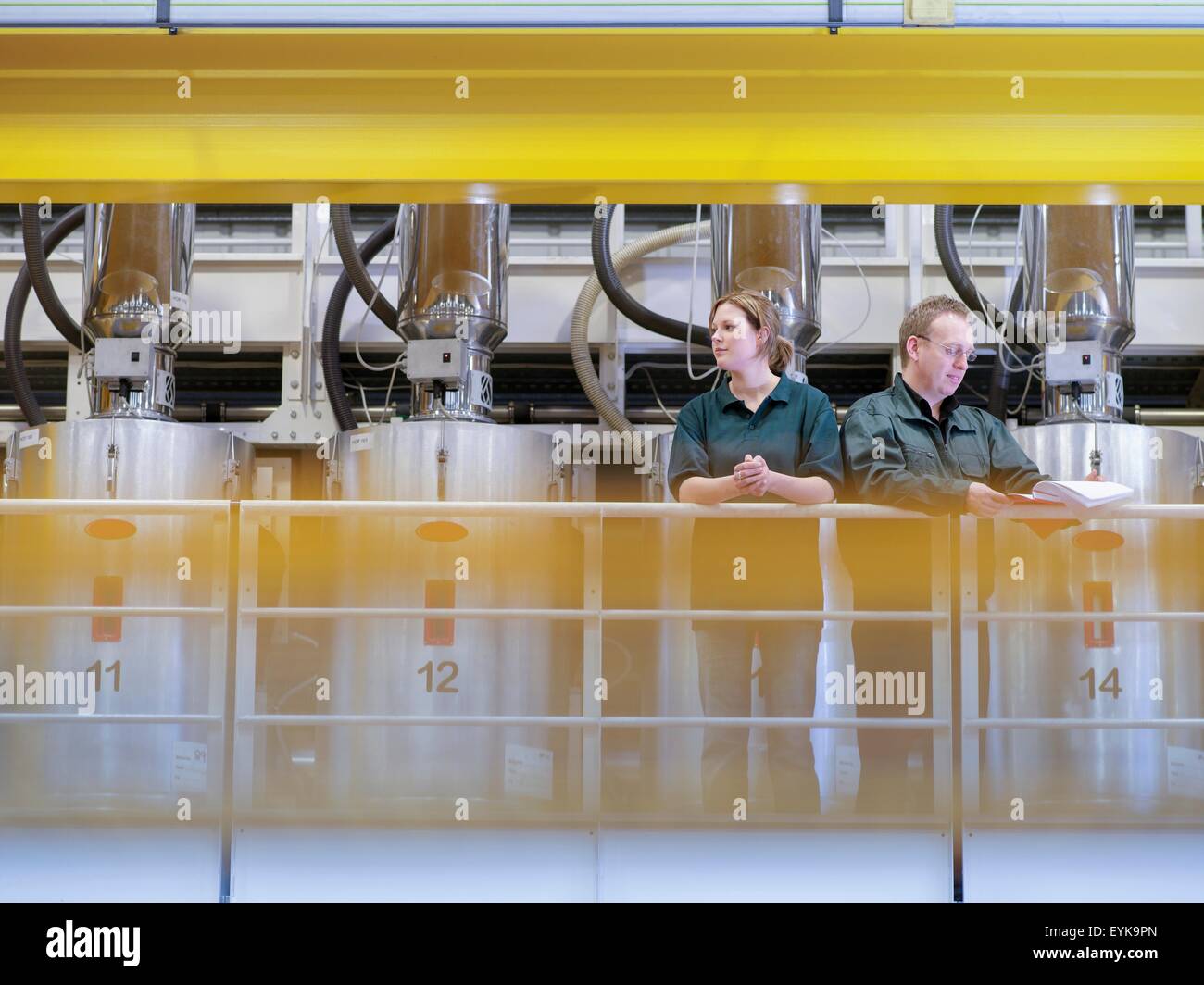 Workers on gantry in factory Stock Photo