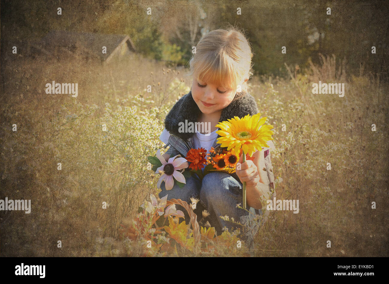 Little blond girl holding autumn flower bouquet in field with sepia vignette. Stock Photo
