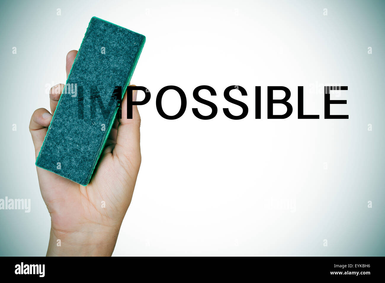 closeup of the hand of a young man deleting the word impossible with an eraser Stock Photo