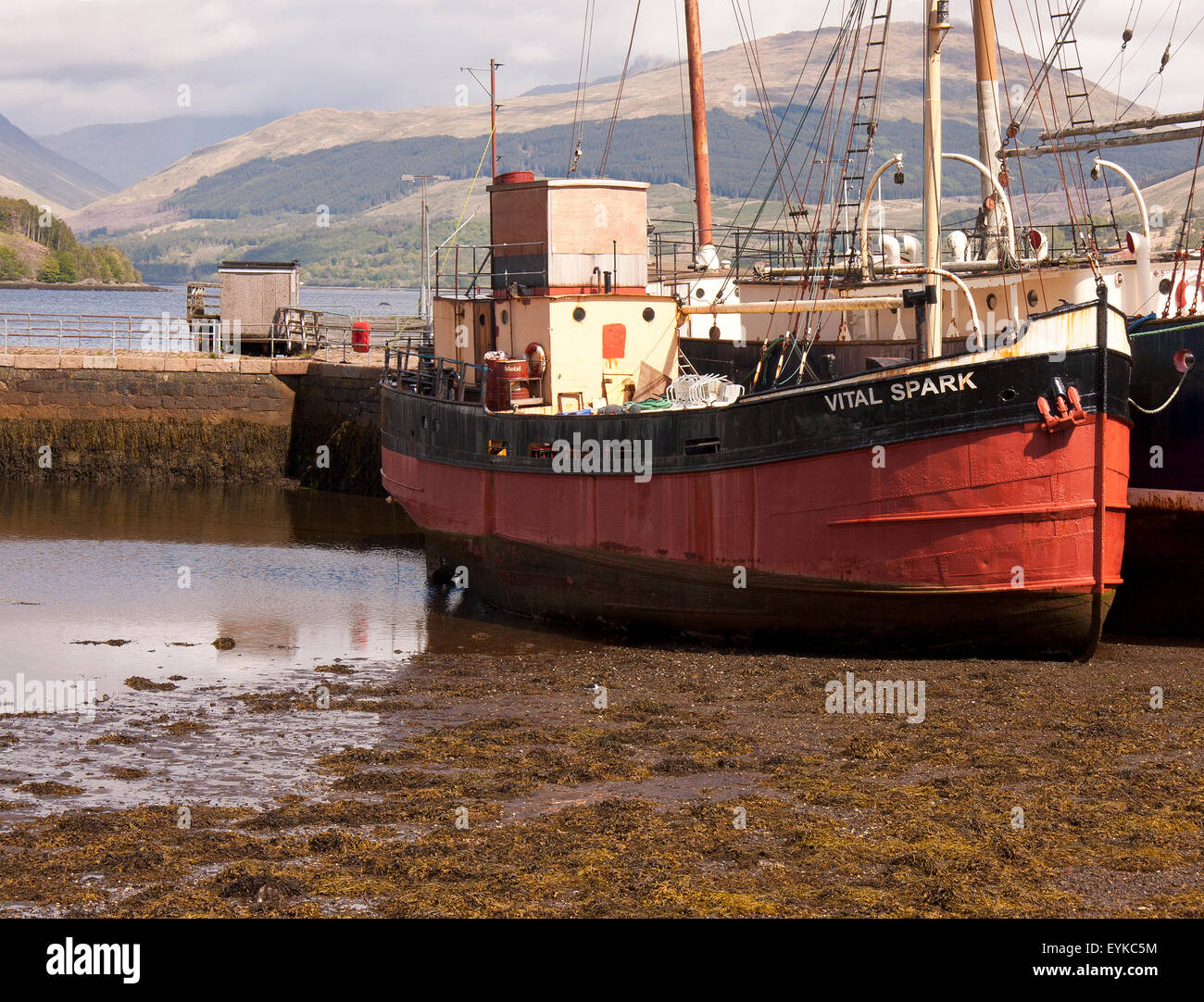 Para Handy's boat the 'Vital Spark' moored on the shores of the Loch Fyne at Inverary, with the mountains in the background. Stock Photo