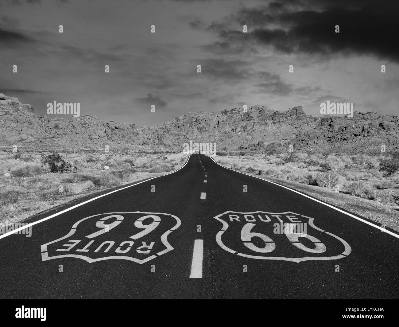 Route 66 black and white pavement sign with Mojave desert background. Stock Photo