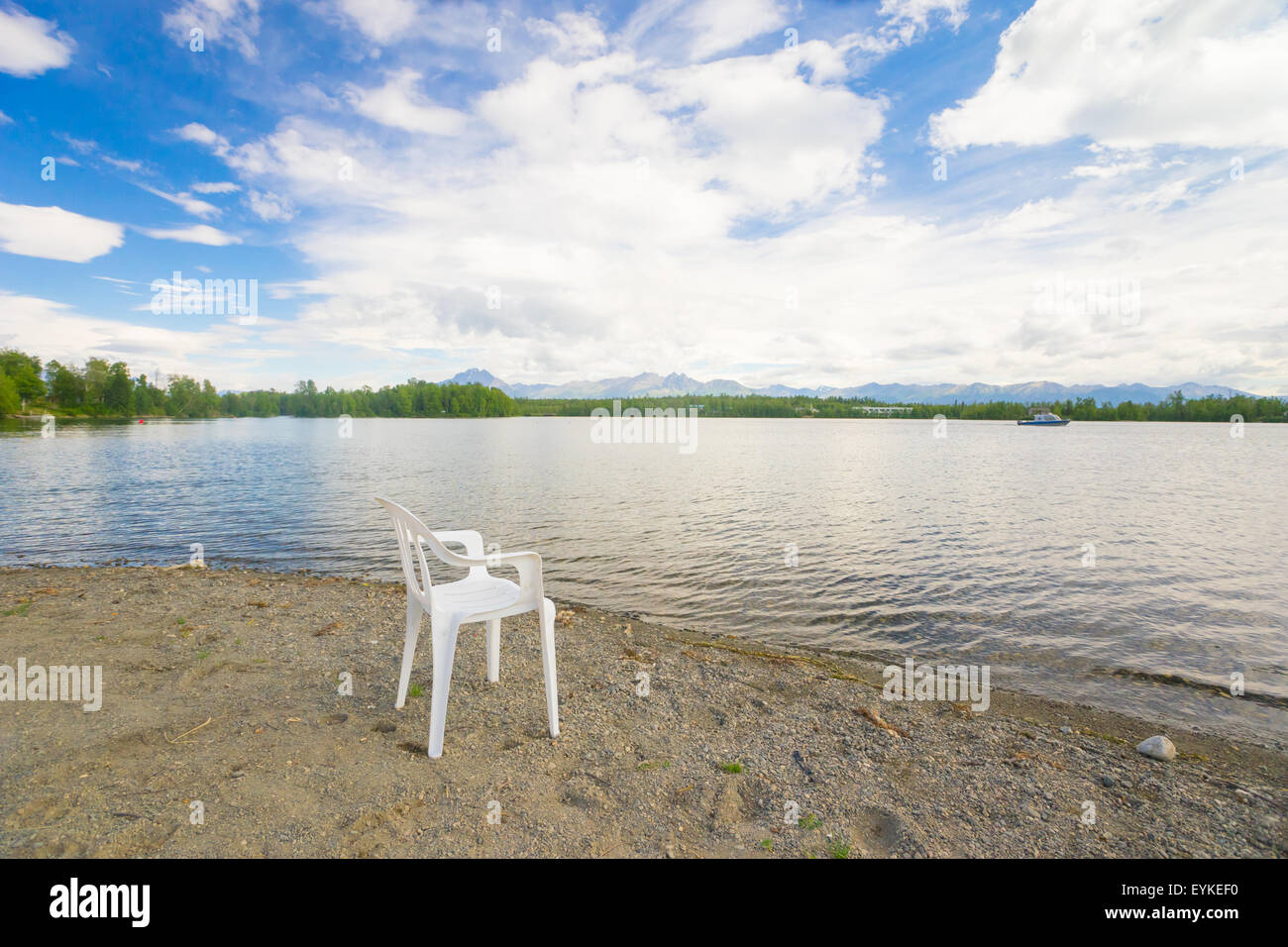 Sand and gravel beach occupied by white plastic lawn chair in Wasilla