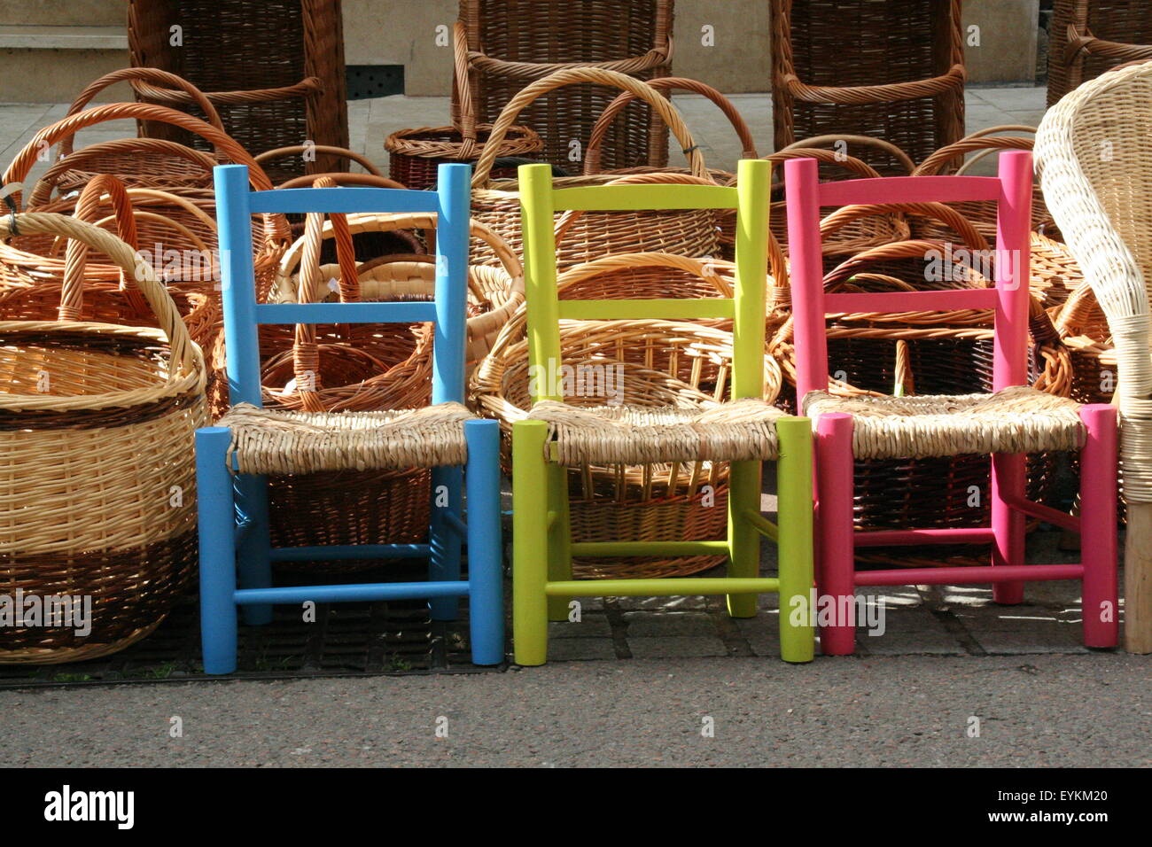 Trio of brightly coloured children's chairs, flea market France. Stock Photo