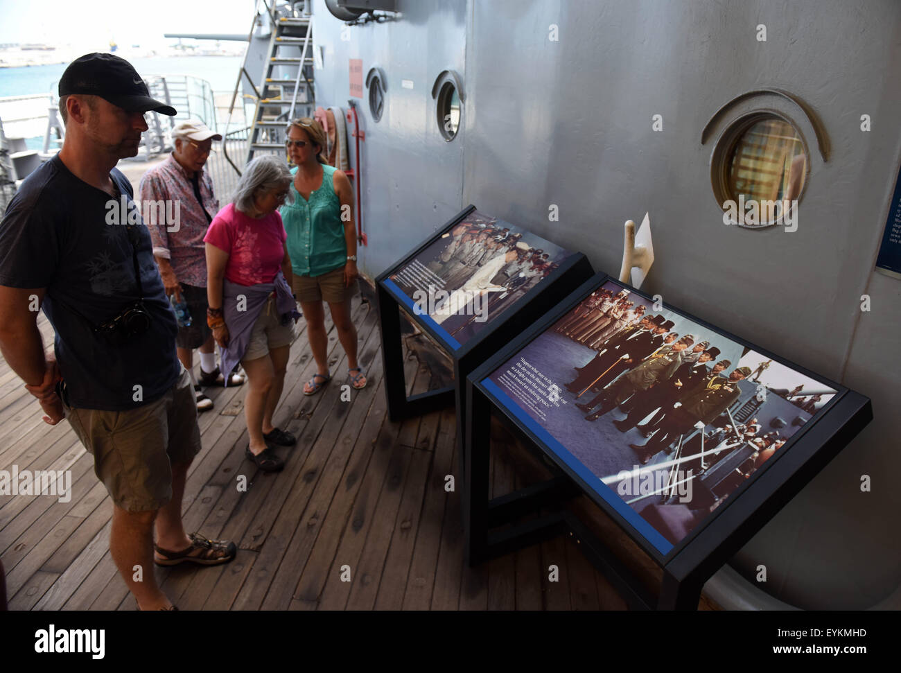 Hawaii, USA. 30th July, 2015. Tourists view pictures of Japanese surrender ceremony at USS Missouri (BB-63) in Honolulu, Hawaii, the United States, July 30, 2015. USS Missouri (BB-63) was the site where Japan signed the surrender documents at the end of the World War II. In 1998, this battleship was donated to the USS Missouri Memorial Association and became a museum ship at Pearl Harbor, Hawaii. © Yin Bogu/Xinhua/Alamy Live News Stock Photo