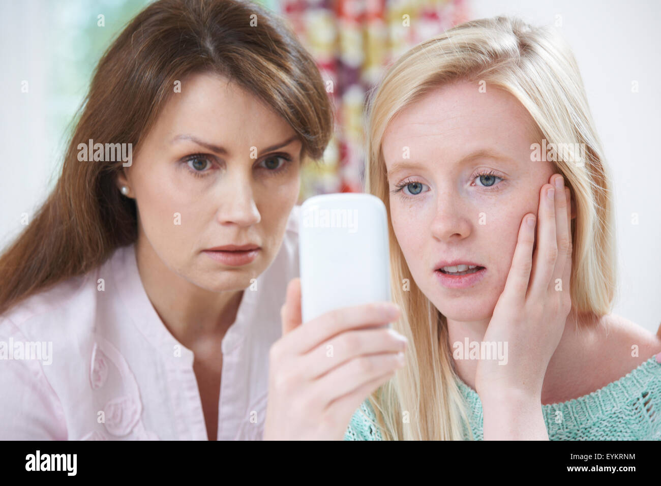 Mother Comforting Daughter Being Bullied By Text Message Stock Photo