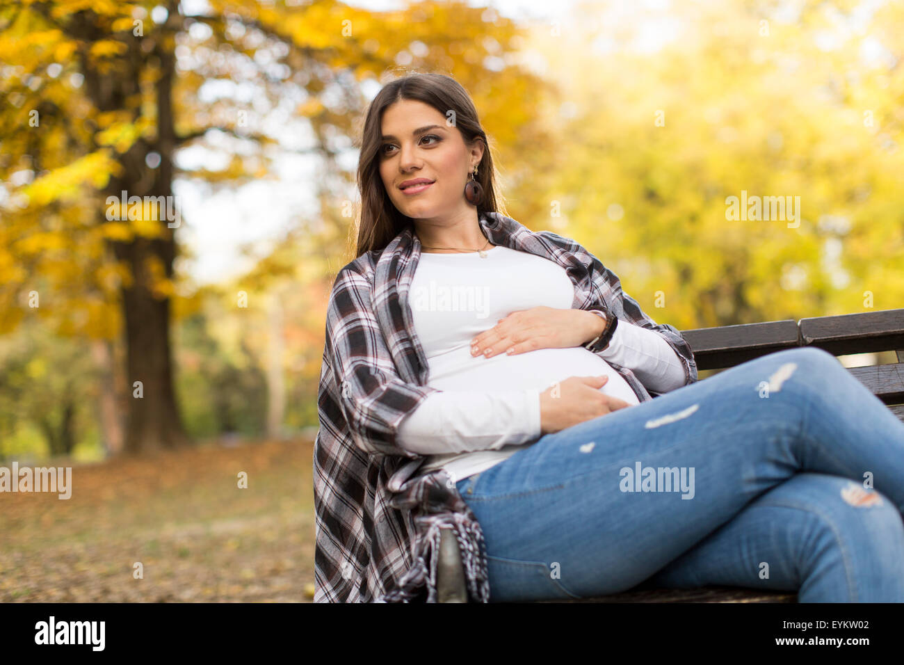 Young pregnant woman sitting in the autumn park Stock Photo - Alamy