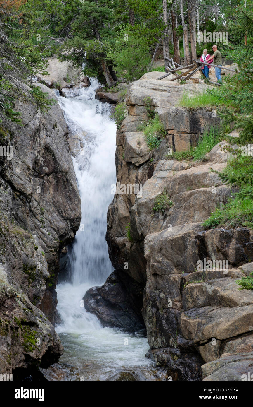 man woman couple viewing Chasm Falls waterfall on Old Fall River Road in Rocky Mountain National Park Colorado Stock Photo