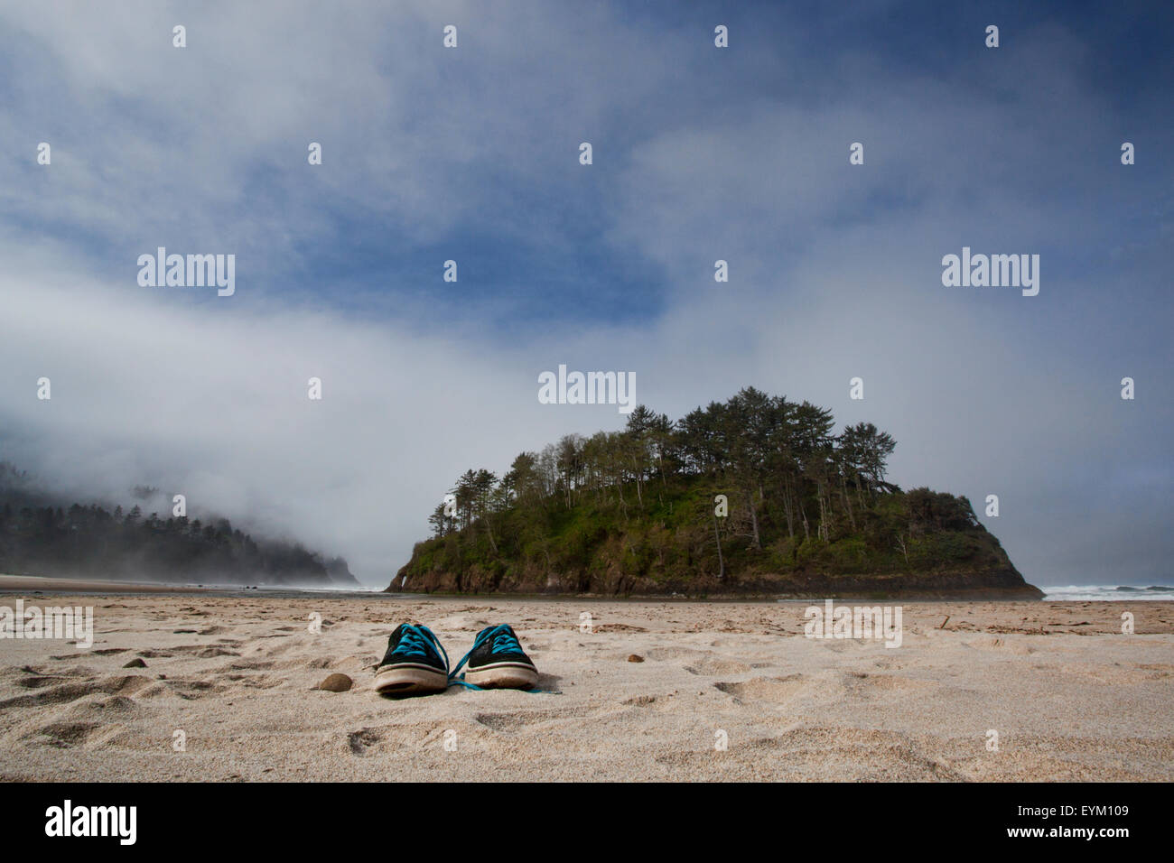 A pair of shoes left on the ocean beach. Stock Photo