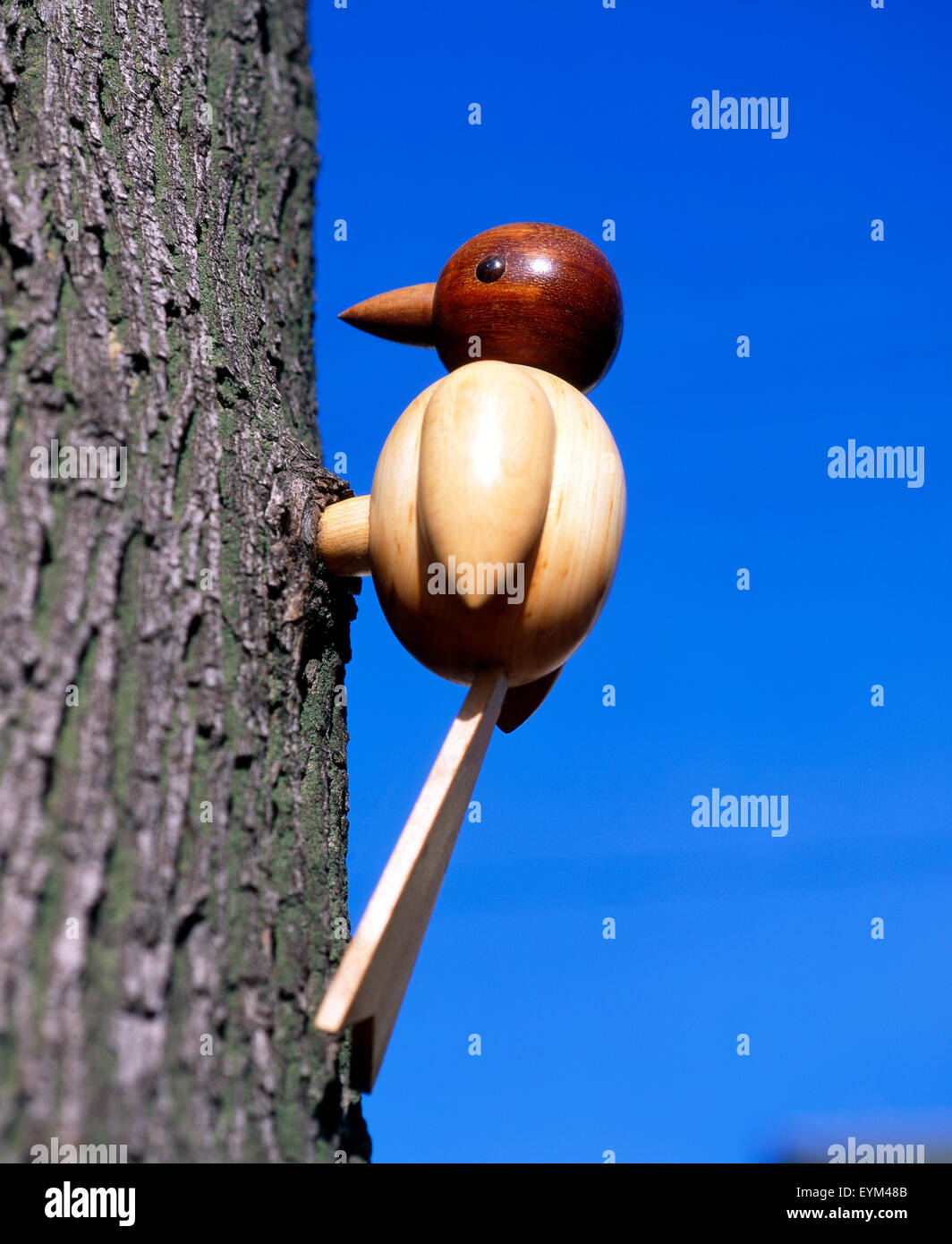 Wooden woodpecker in trunk as a jewellery element at garden, Stock Photo