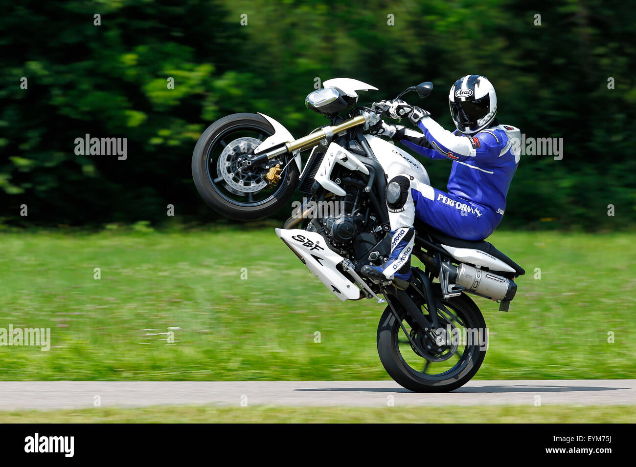 Motorcycle, three-cylinder engine, Triumph Streettriple, year of construction in 2012, Wheelie on country road, Stock Photo