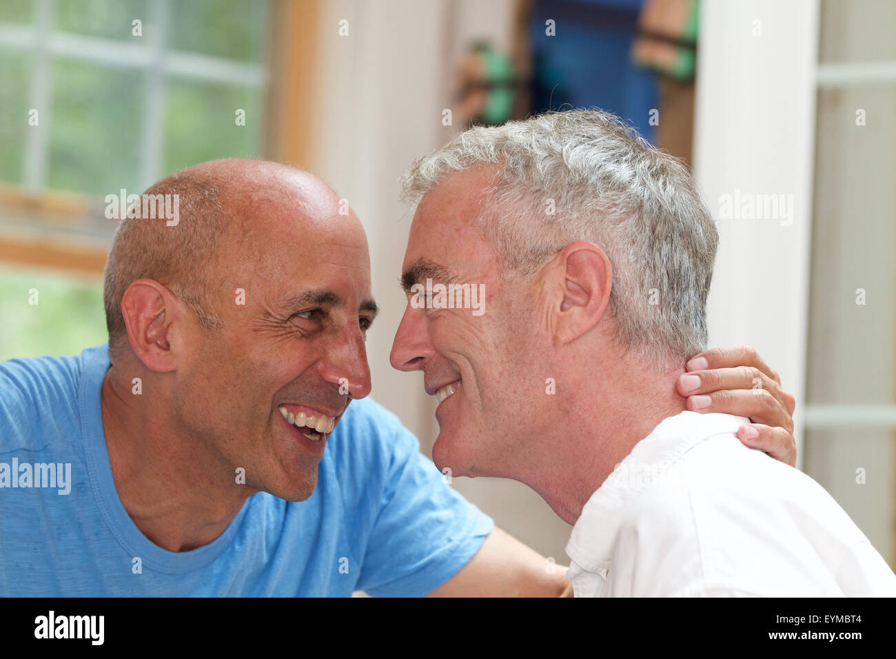 Senior gay couple on vacation being affectionate, laughing and smiling, at bed and breakfast Stock Photo