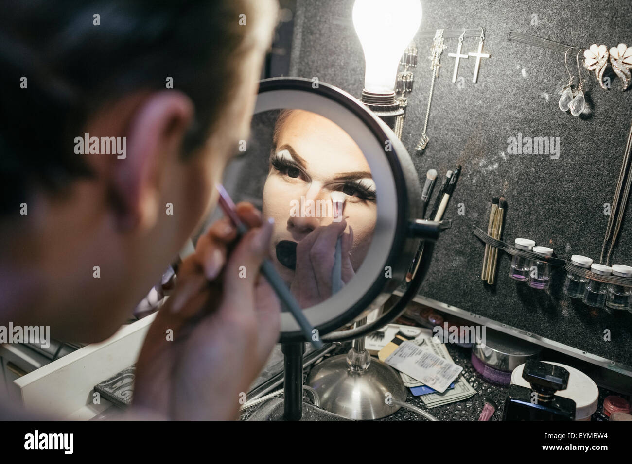 Male drag queen putting on make up and dressing up in preparation for a performance Stock Photo