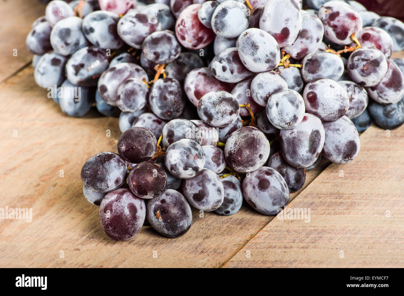 A bunch of fresh red grapes on a wooden table Stock Photo