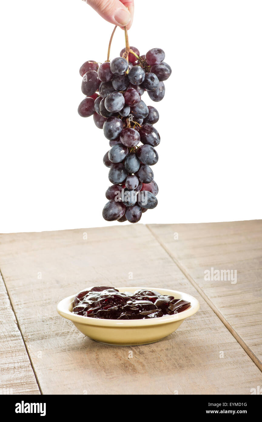 Grapes being dropped into a bowl of grape jelly Stock Photo Alamy
